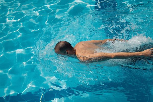 Man die zwemt in een openbaar zwembad