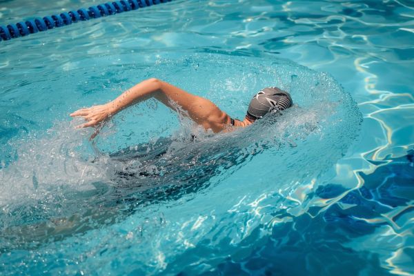 vrouw die crawl zwemt in een openbaar zwembad